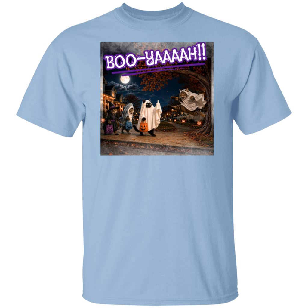A light blue short-sleeve t-shirt with a colorful graphic print of a Halloween night scene featuring cat's going trick or treating, and a cat jumping out from behind a tree, dressed as a ghost, to scare the other cats, and the text 'BOO - YAAAAAH!!' in purple neon, worn by a model. The cat that was the intended target is holding up it's middle finger under it's costume as an automatic response to the annoying ghost.