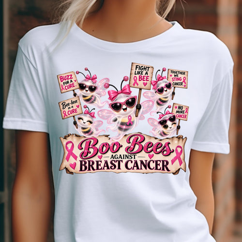 A white short-sleeve graphic T-shirt worn by a model, featuring cartoon bees in pink sunglasses holding breast cancer awareness signs with the text 'Boo Bees Against Breast Cancer' and pink ribbons.