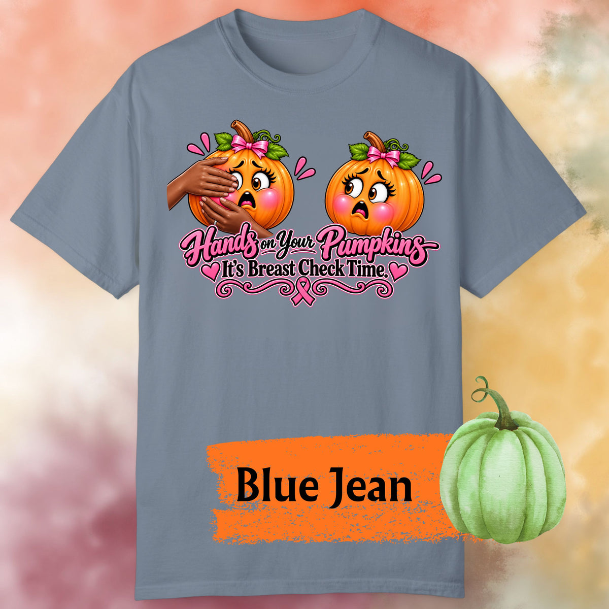 A blue-gray graphic t-shirt  with a playful Breast Cancer Awareness Halloween design featuring two adorably horrified pumpkins, pink bows, pink accents, a breast cancer awareness ribbon and the cheeky reminder: “Hands on Your Pumpkins — It's Breast Check Time!” One of the pumpkins is being squeezed.