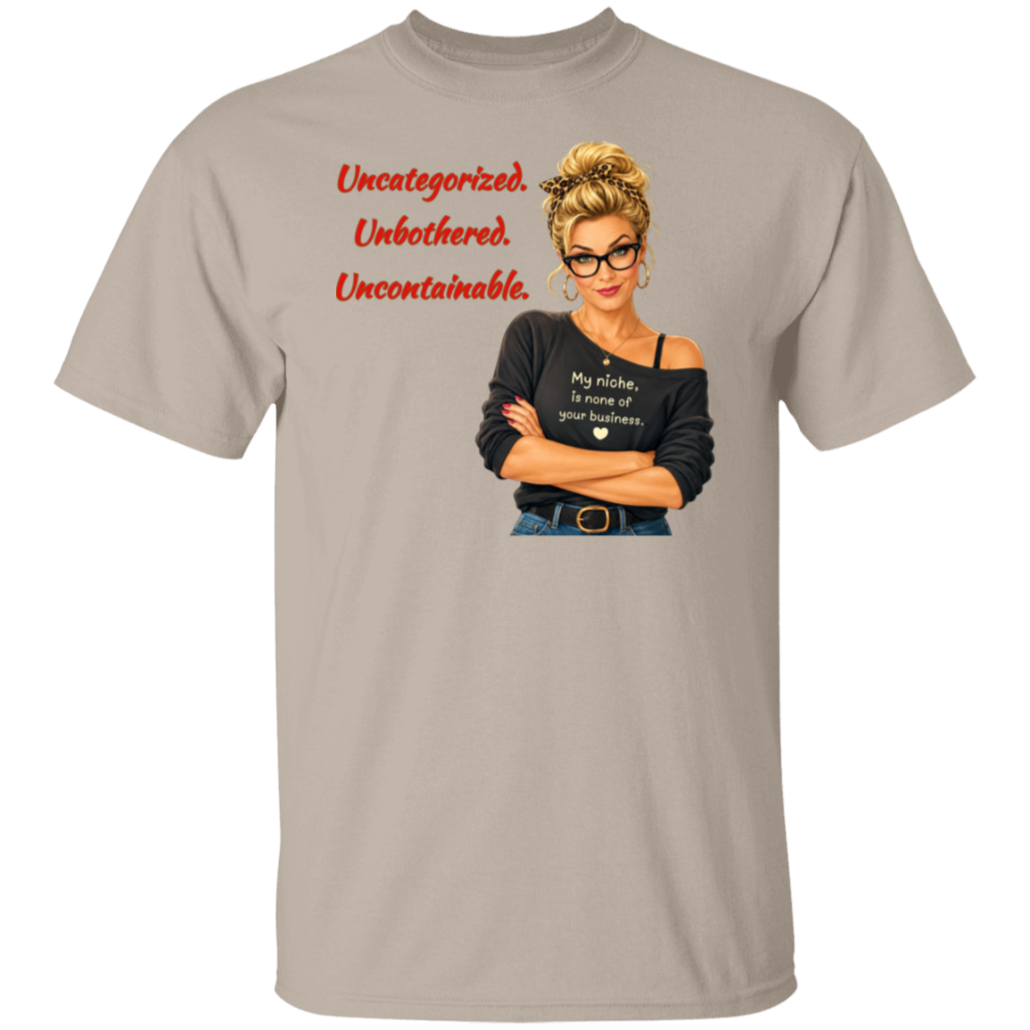 A light beige short-sleeve t-shirt with a graphic print on the front. The graphic features a retro-style illustration of a blonde woman in glasses wearing a black off-the-shoulder shirt with the text  'My niche, is none of your business.", along with "Uncategorized", "Unbothered", "Uncontainable" written in red letters.