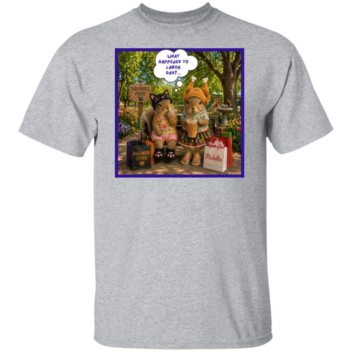 A heather gray short-sleeve crewneck t-shirt featuring a colorful graphic print on the chest. The print shows two fashionable squirrel besties are taking a well-deserved shopping break at Squirrel Park. One is clearly ready for spooky season in her cat costume, while the other has apparently skipped straight past fall and landed somewhere between Thanksgiving and Christmas—iced coffee in hand, naturally. Surrounded by shopping bags and seasonal chaos, one squirrel wonders "What Happened to Labor Day?".