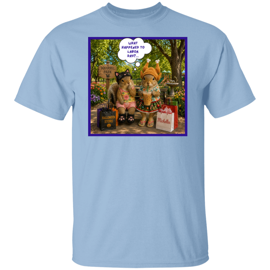 A light blue crewneck t-shirt featuring a colorful graphic print on the front. The print shows two fashionable squirrel besties are taking a well-deserved shopping break at Squirrel Park. One is clearly ready for spooky season in her cat costume, while the other has apparently skipped straight past fall and landed somewhere between Thanksgiving and Christmas—iced coffee in hand, naturally. Surrounded by shopping bags and seasonal chaos, one squirrel wonders "What Happened to Labor Day?"