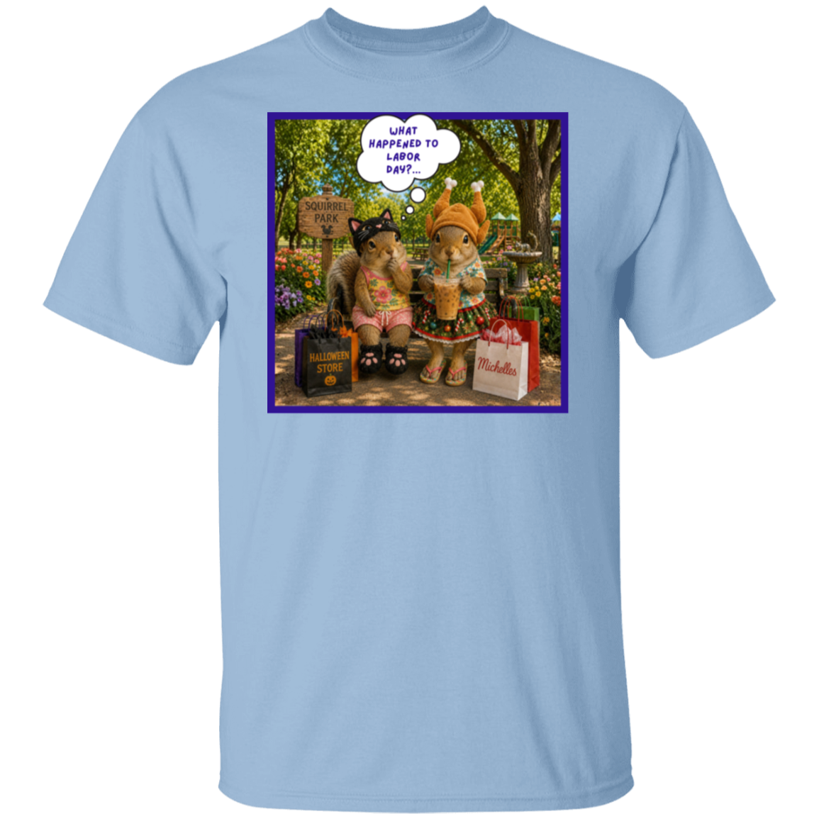 A light blue crewneck t-shirt featuring a colorful graphic print on the front. The print shows two fashionable squirrel besties are taking a well-deserved shopping break at Squirrel Park. One is clearly ready for spooky season in her cat costume, while the other has apparently skipped straight past fall and landed somewhere between Thanksgiving and Christmas—iced coffee in hand, naturally. Surrounded by shopping bags and seasonal chaos, one squirrel wonders "What Happened to Labor Day?"