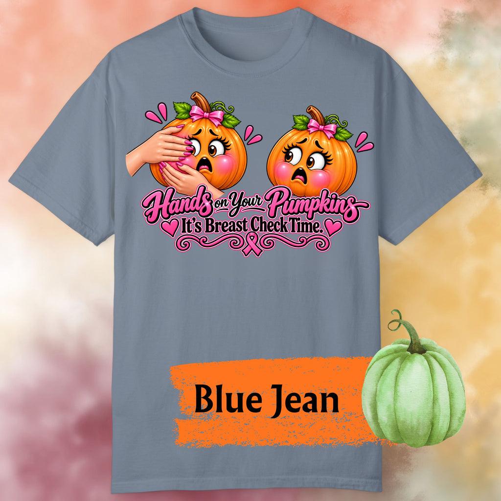 A blue jean colored short-sleeve graphic t-shirt, featuring a humorous  important reminder with this funny Breast Cancer Awareness Shirt, created for women who like their Pink October message with a little sass. This playful Breast Cancer Awareness Halloween design features two adorably horrified pumpkins, pink bows, pink accents, a breast cancer awareness ribbon and the cheeky reminder: “Hands on Your Pumpkins — It's Breast Check Time!” while what hands are squeezing the one pumpkin for lumpkins.