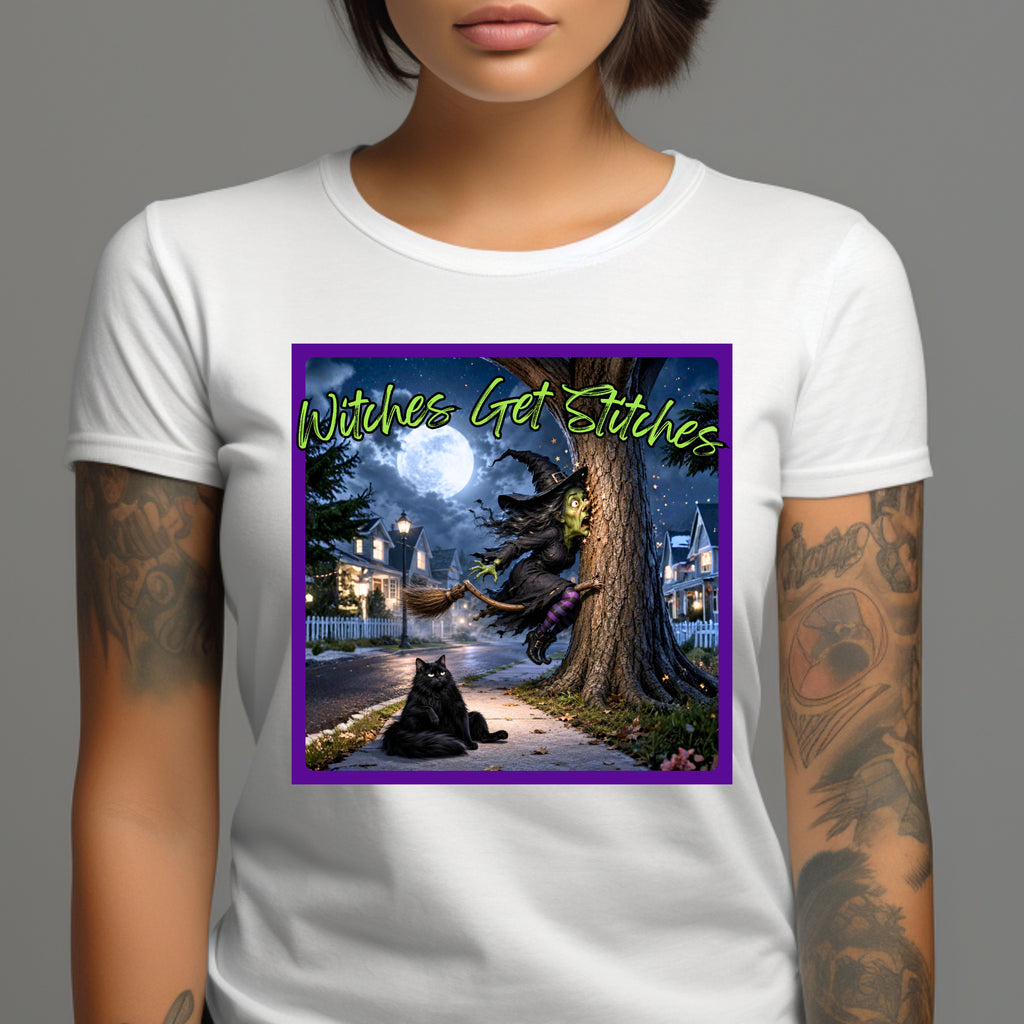 A white short-sleeve t-shirt worn by a model, featuring a colorful graphic print on the front. This hilarious “Witches Get Stitches” written in lime green, design captures the unfortunate aftermath of one witch’s high-speed broom ride as she finds herself spectacularly wrapped around a tree. Under a glowing full moon, our frazzled witch looks completely shocked by her sudden stop—while her fluffy black cat sits nearby with the wonderfully unimpressed expression of someone who absolutely saw this coming. 
